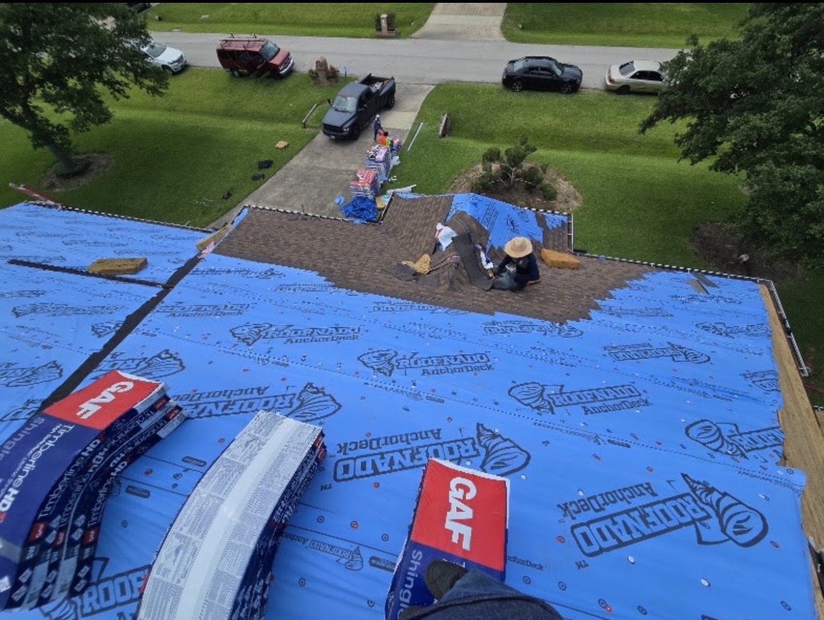 Roofing crew installing shingles on a residential roof